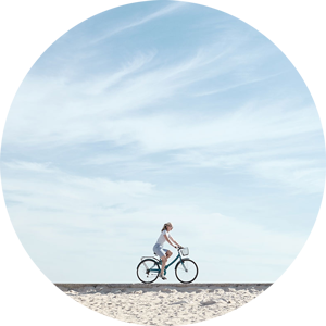 Lady riding her bike alone the beach