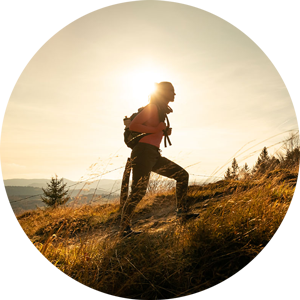 Women climbing mountain at sunset